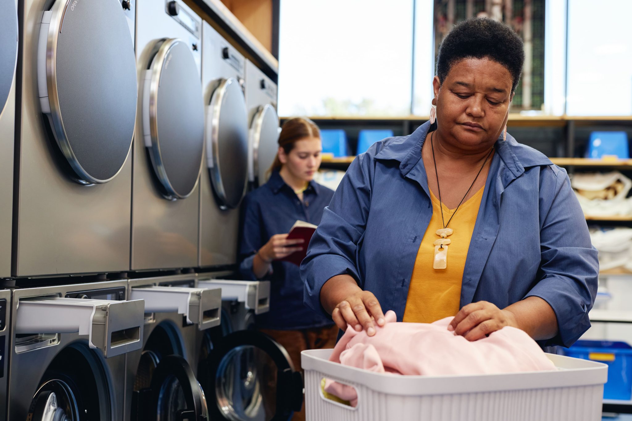 senior-black-woman-sorting-through-clothes-in-bask-2025-03-09-14-26-34-utc